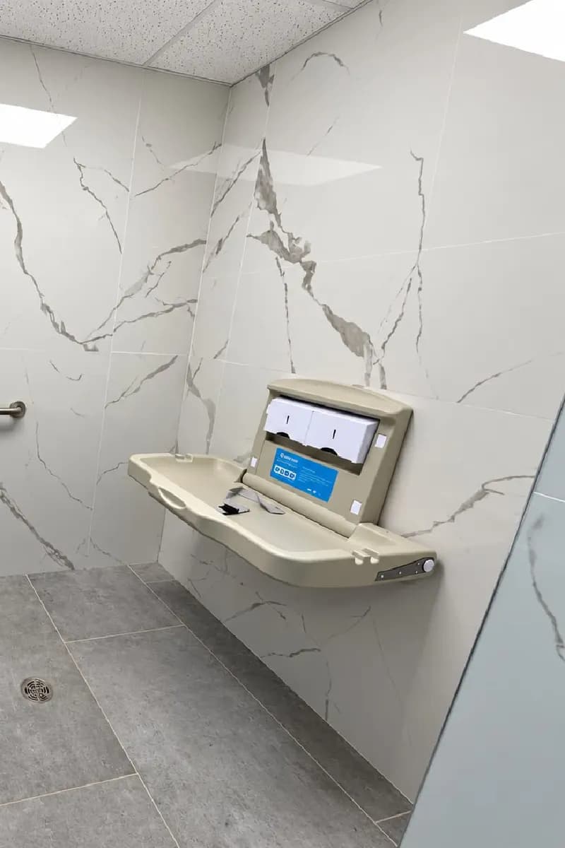 Restroom with a baby changing station mounted on the wall